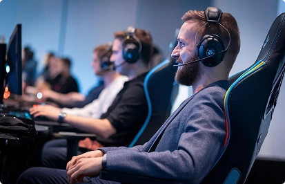 Een professionele gamer zit met een headset op in een gamingstoel en neemt deel aan een e-sportwedstrijd.