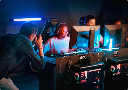 Een fotograaf fotografeert gamers die achter hun computers zitten tijdens een e-sporttoernooi.